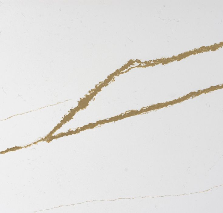 a white marble counter top with gold streaks on it's edges and a black object in the middle