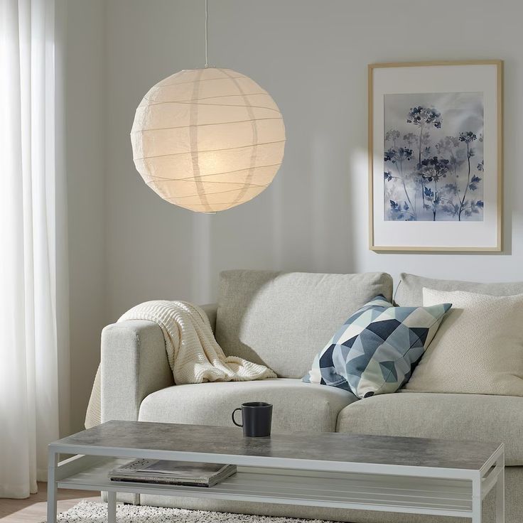 a living room with a couch, coffee table and hanging lantern in the corner on the wall