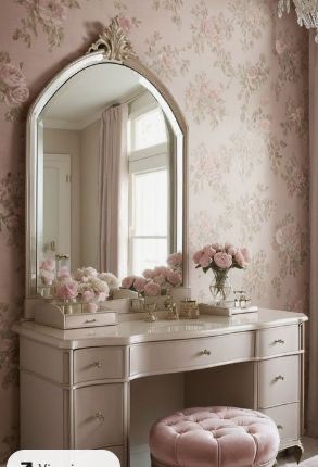 a vanity with a mirror, stool and flowers on the wall