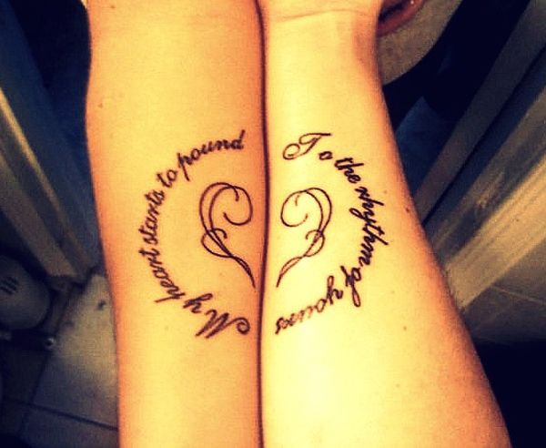 two people with matching tattoos on their arms, one has a heart and the other has an inscription