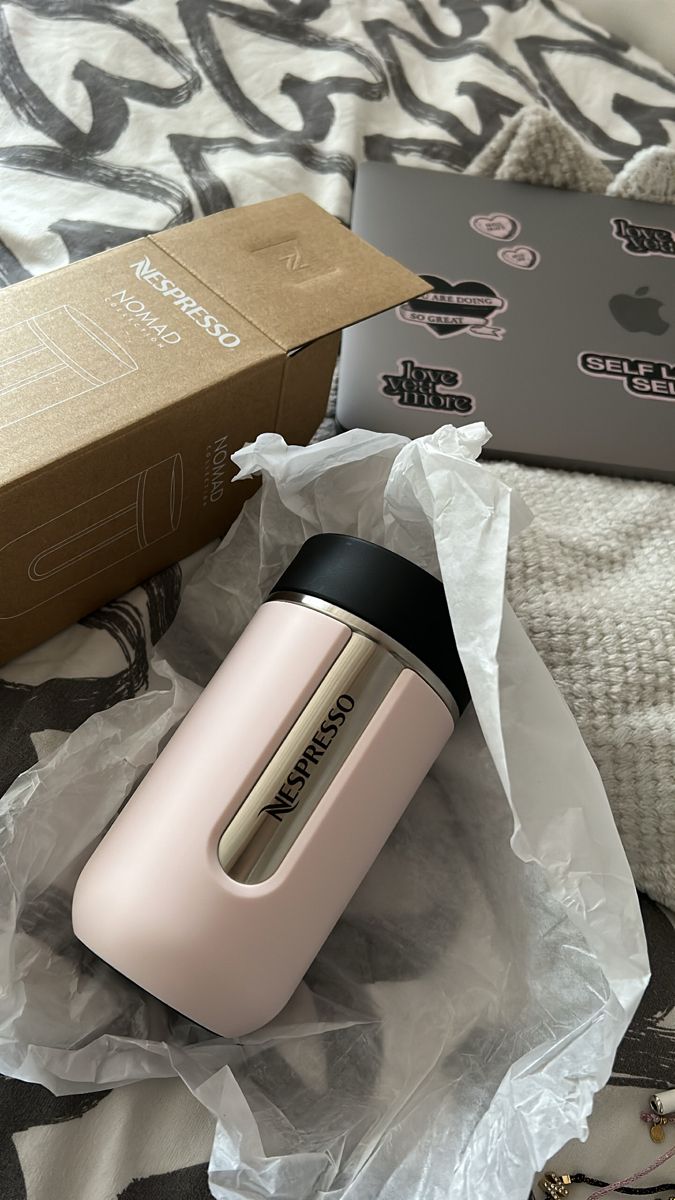 an open box sitting on top of a bed next to a pink hair dryer