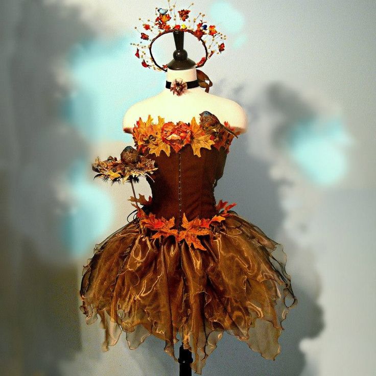 a dress made out of leaves and flowers on a mannequin headdress