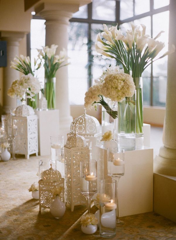 vases filled with flowers and candles on a table