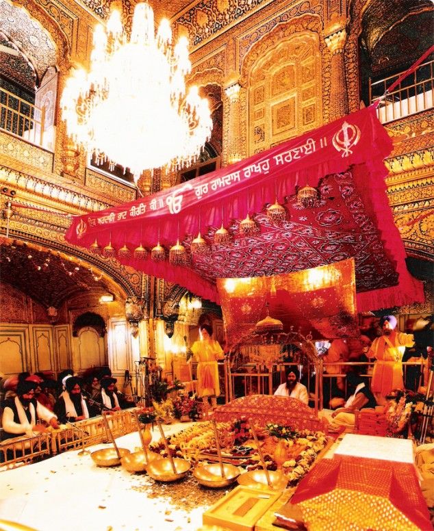 a group of people sitting around a table in a room with chandeliers hanging from the ceiling