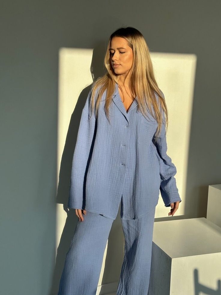 "Our women's loungewear set is the epitome of comfort and style. Made from 100% organic cotton muslin, it offers a lightweight, natural texture that not only feels incredibly soft against your skin but also drapes elegantly. The oversized shirt and high-waisted trousers create a perfect balance between fashion and relaxation, making it ideal for your leisure time or a getaway. With its handmade quality, breathable fabric, and the added convenience of pockets in the pants, this loungewear set is Oversized Long Sleeve Sets For Daywear, Blue Relaxed Fit Lounging Sets, Blue Relaxed Fit Loungewear Sets, Blue Relaxed Fit Lounge Sets, Relaxed Fit Blue Lounge Sets, Relaxed Fit Long Sleeve Sets, Comfortable Oversized Loungewear Sleepwear, Oversized Cotton Sleepwear In Relaxed Style, Relaxed Fit Sleep Sets