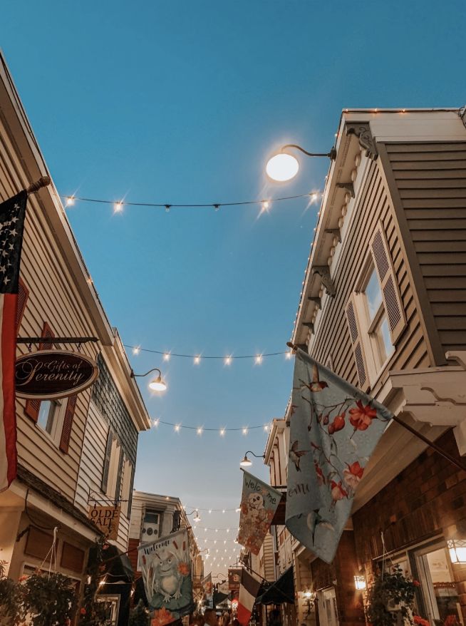 people are walking down the street in front of buildings with american flags hanging from them