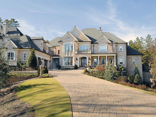 a large house with lots of windows on the front and side of it's driveway