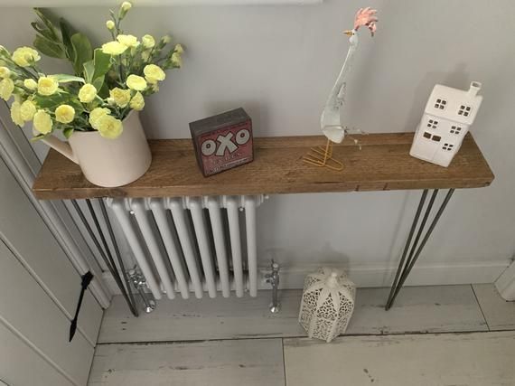 a radiator and some flowers on a wooden shelf