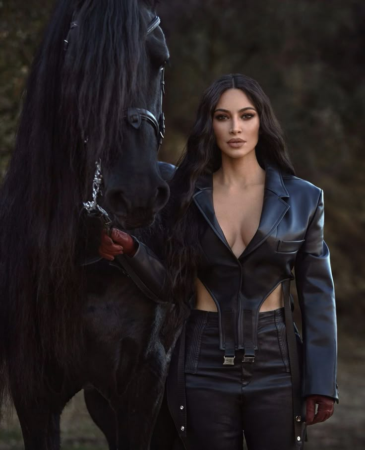 a woman standing next to a black horse