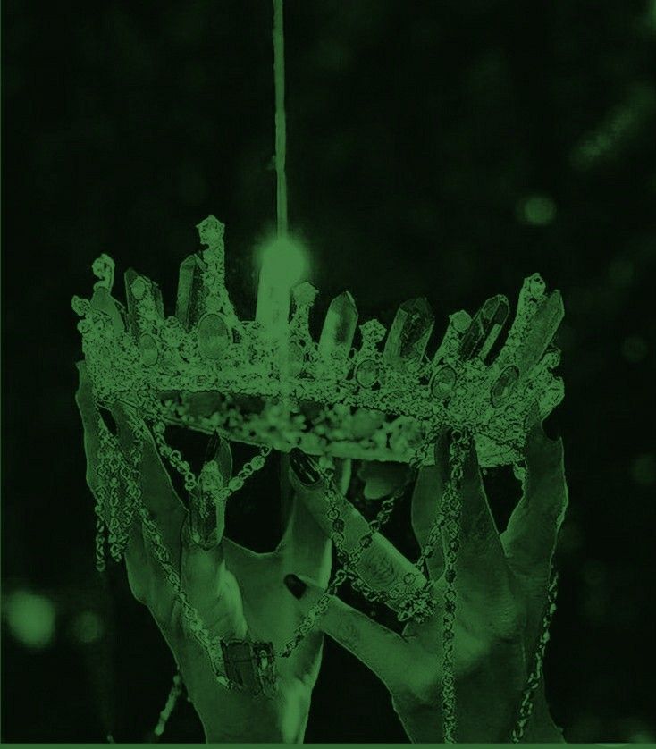 two hands holding up a green object in the air with water droplets on it's sides