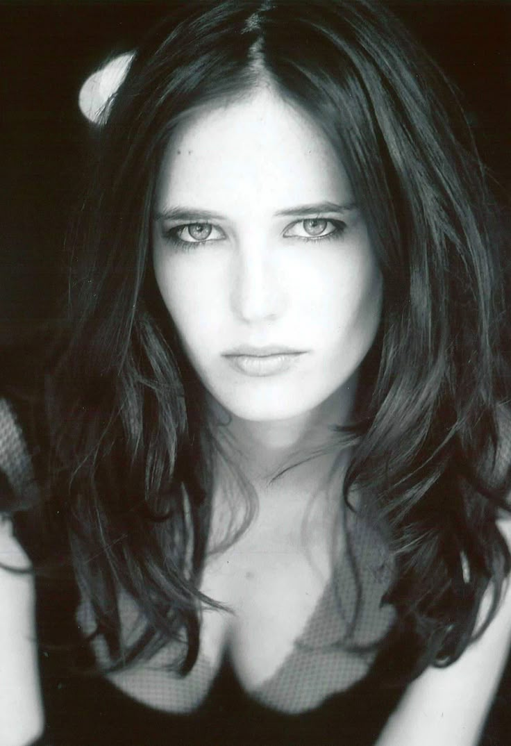 a black and white photo of a woman with long hair, wearing a bra top