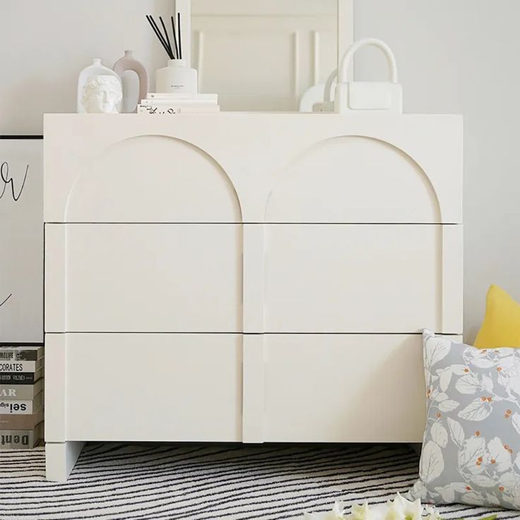 a white dresser sitting on top of a striped rug