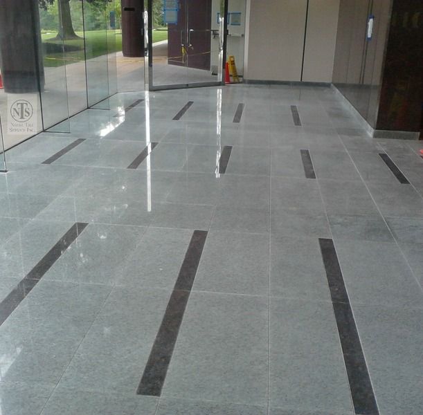 an empty lobby with marble floors and glass doors