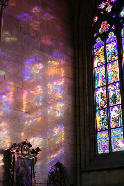 sunlight streaming through the stained glass windows in an old church, with a mirror on the floor