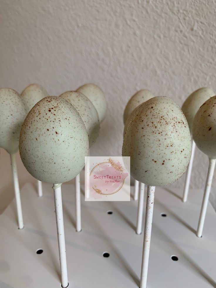 there are many cake pops with speckled toppings on the top one is white