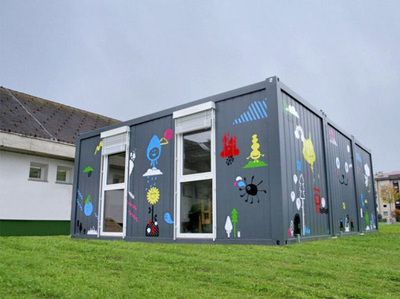 a building made out of shipping containers in the grass