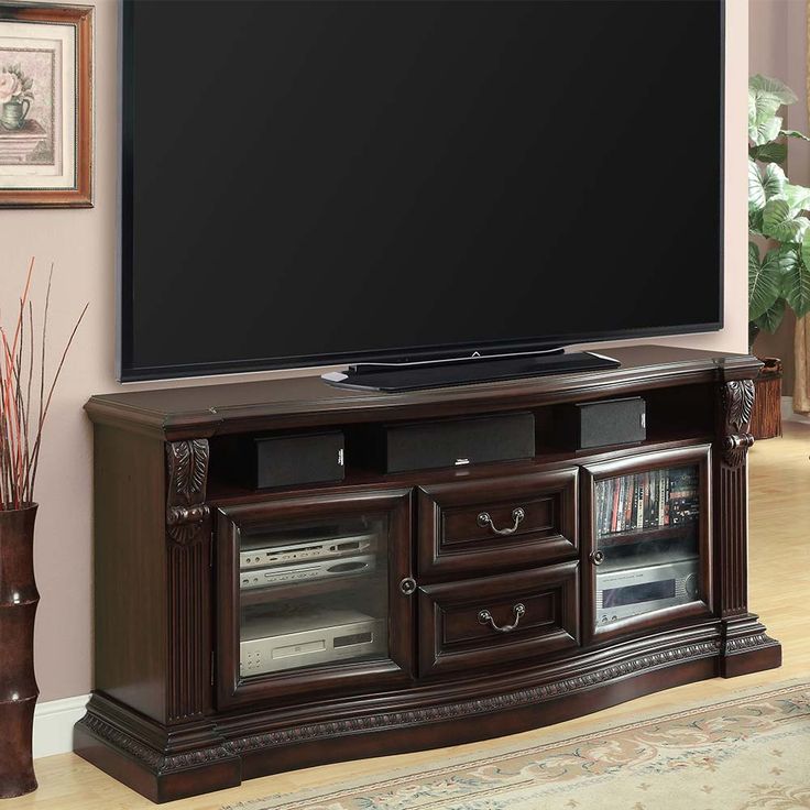 a large flat screen tv sitting on top of a wooden entertainment center cabinet in a living room