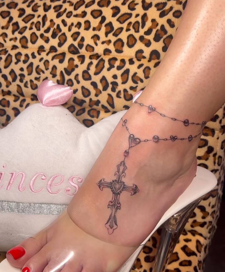 a woman's foot with a cross tattoo on it