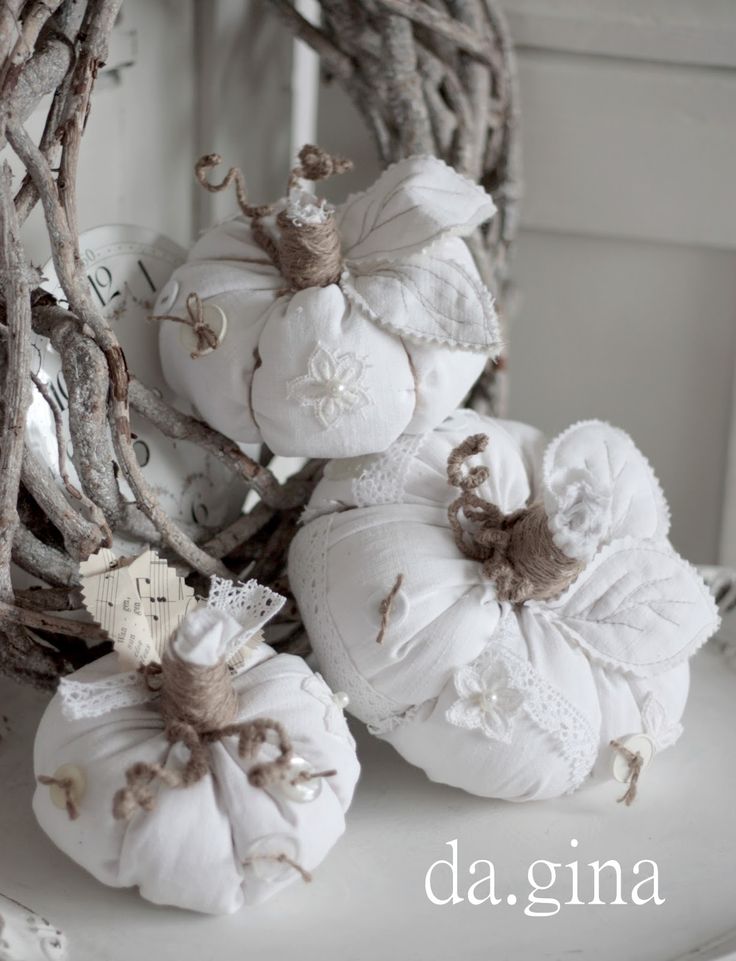 white pumpkins are arranged in a wreath on top of a shelf with twigs and branches