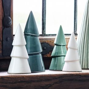 three ceramic trees sitting on top of a window sill