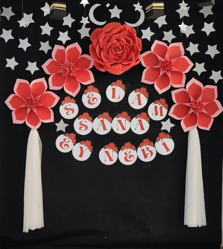 a black and white backdrop with red flowers, stars and tassels on it