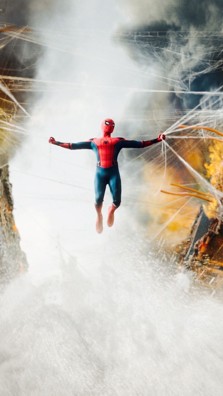 a man in a red and blue suit jumping into the air with his arms outstretched