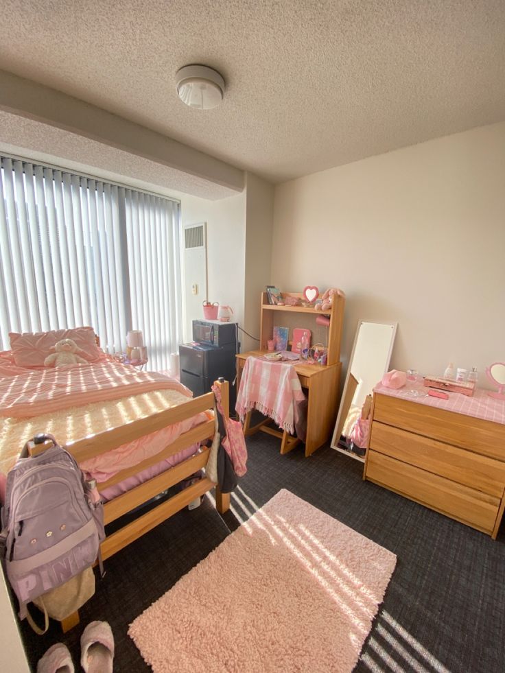 a child's bedroom with pink and white bedding, rugs and furniture