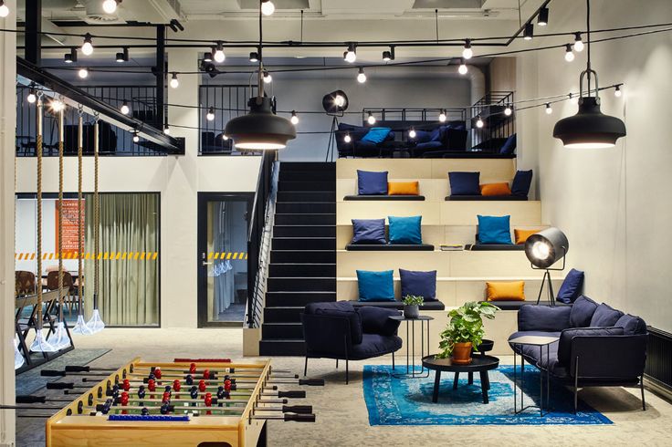 a living room filled with furniture and lots of lights hanging from the ceiling next to a stair case