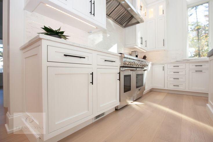 a kitchen with white cabinets and an oven