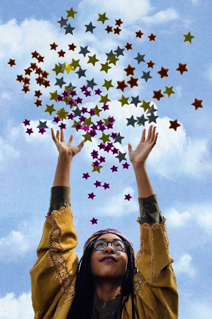 a woman with her hands in the air surrounded by stars