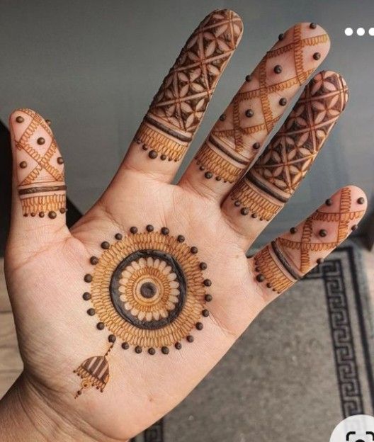 a person's hand with hennap on it and an intricate circular design