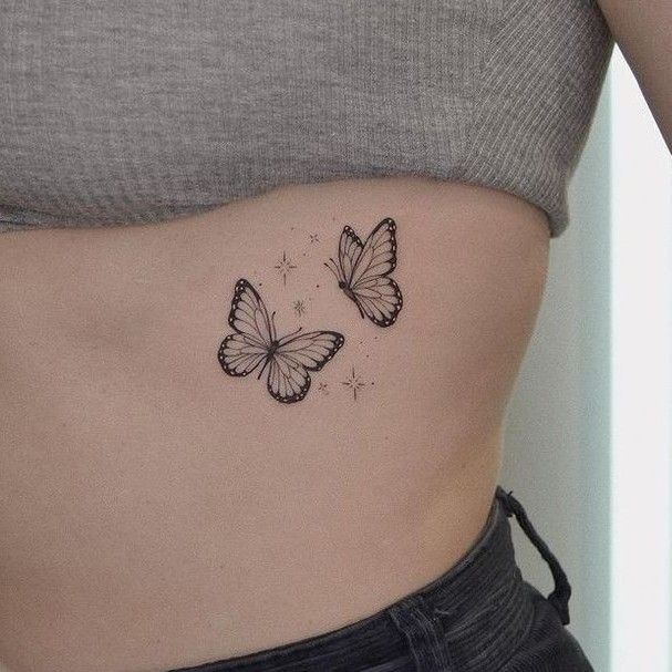 two butterflies on the side of a woman's stomach, one is black and white