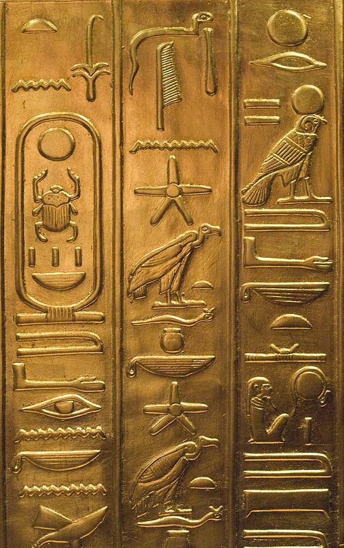 an egyptian gold hieroglyphic with symbols on it