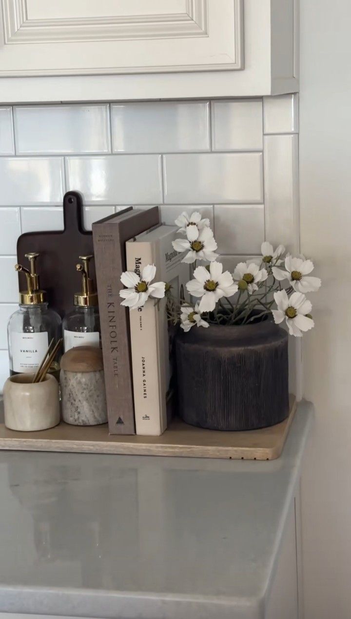 some books and flowers are sitting on a shelf