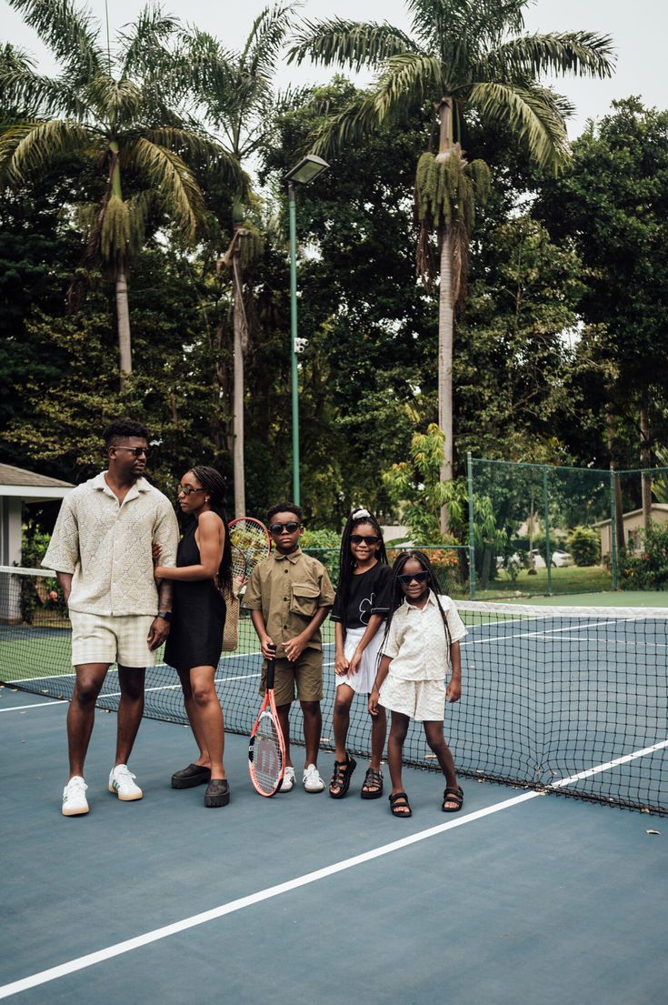 a group of people standing on top of a tennis court