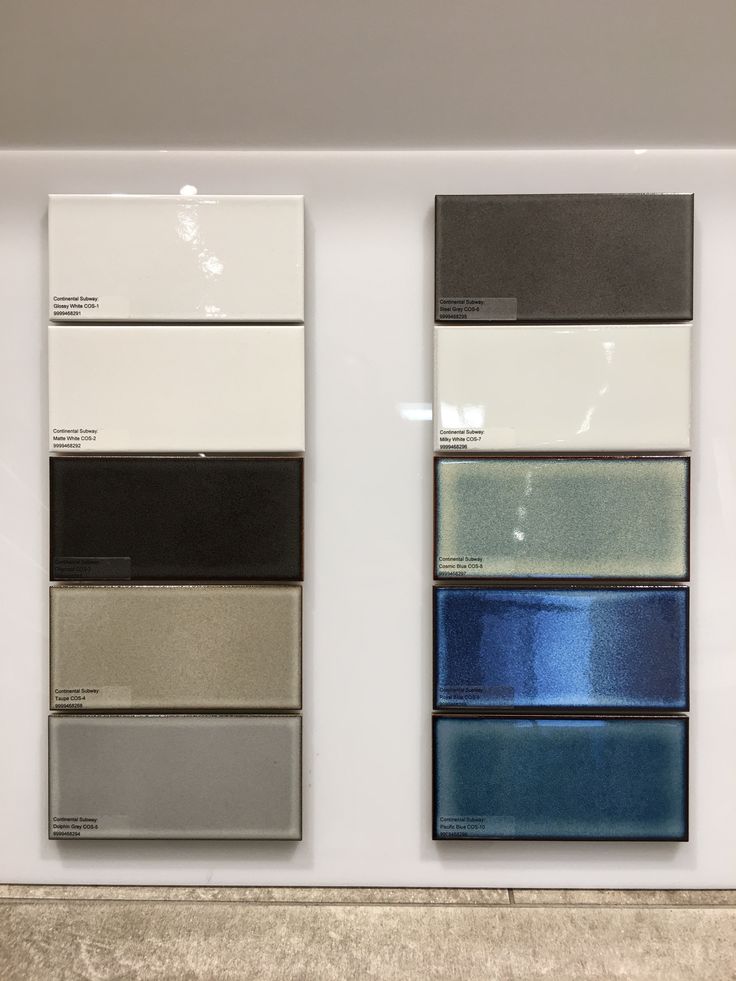 several different colors of paint on display in a store window with white and gray walls