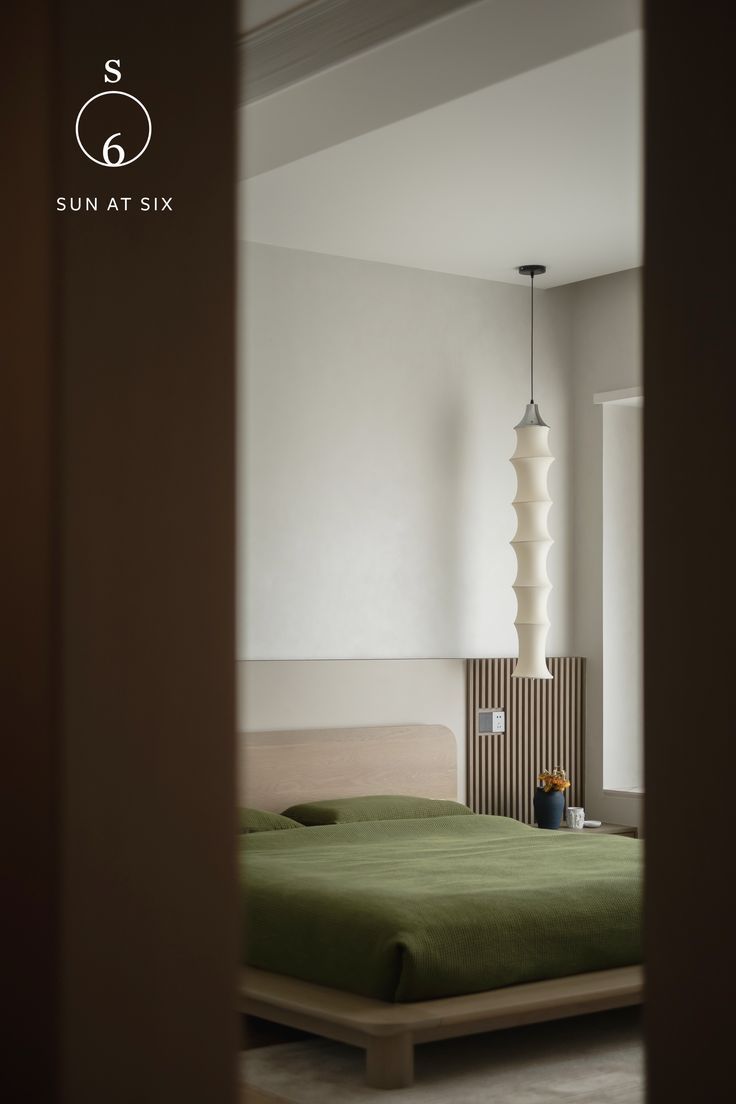 a bed sitting in the middle of a bedroom next to a wall mounted light fixture