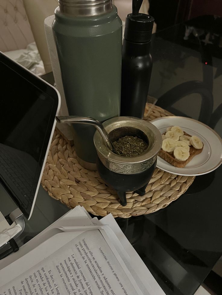 a table topped with a laptop computer next to a bowl of food