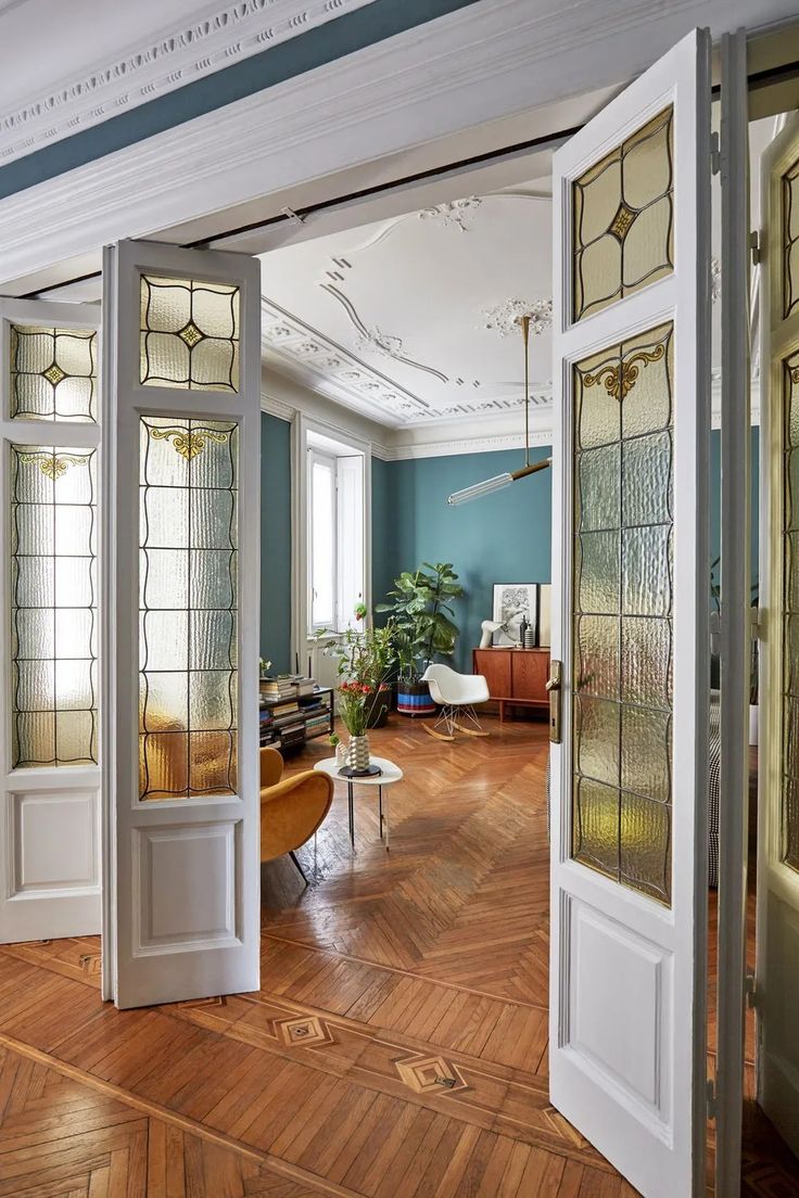 an open door leading into a living room with wood flooring and walls painted blue