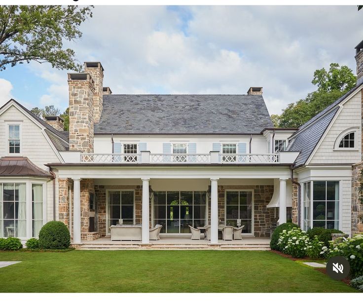 a large white house sitting on top of a lush green field