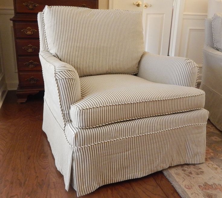 a striped chair sitting on top of a hard wood floor next to a white door