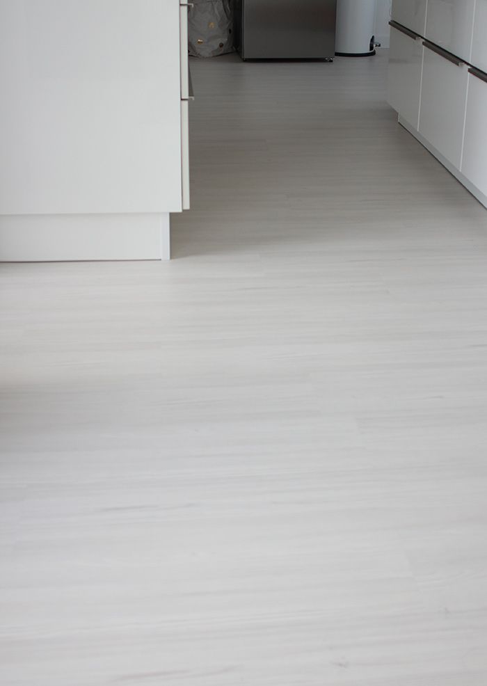 an empty kitchen with white cabinets and flooring is pictured in this image from the front view