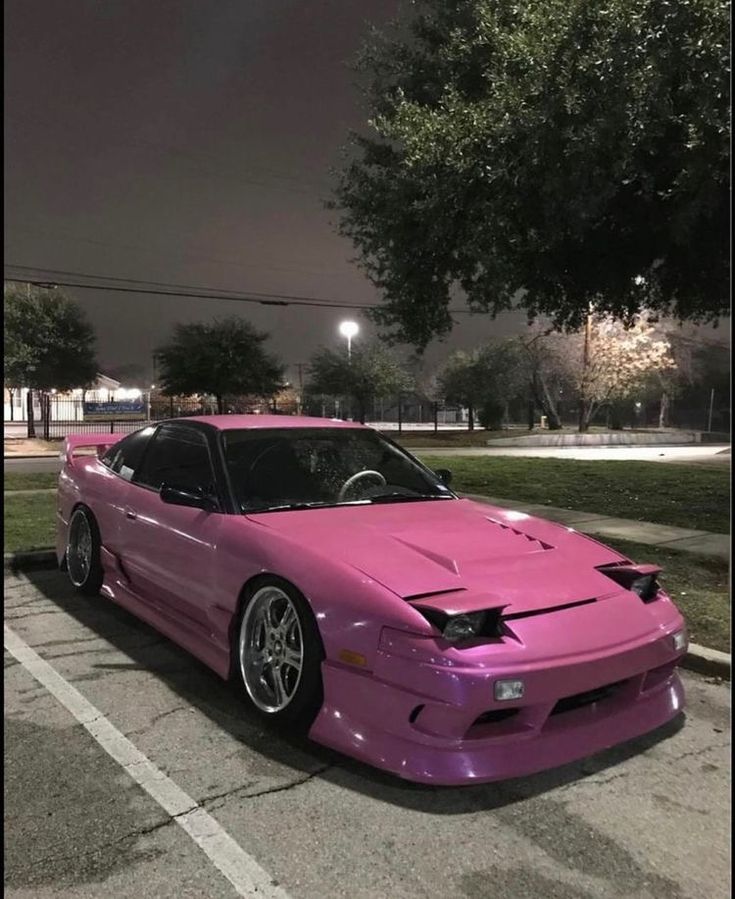 a pink sports car parked in a parking lot