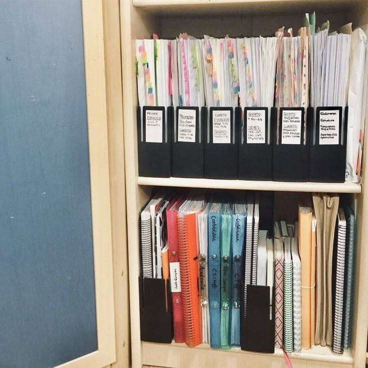 a book shelf filled with lots of books and binders