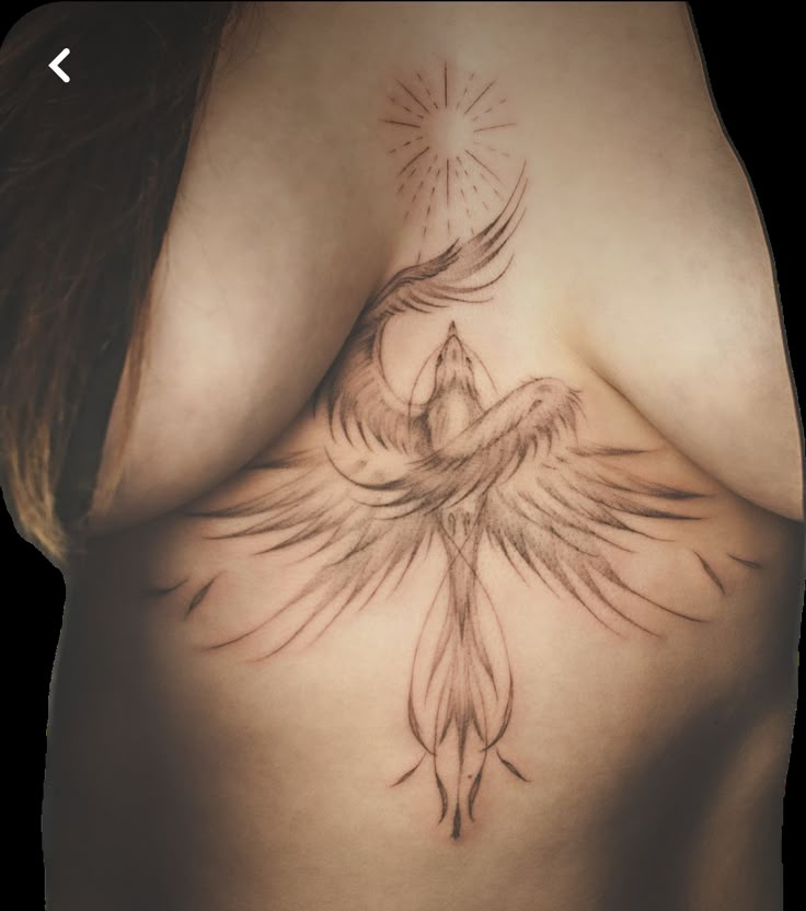 a woman's breast with a bird tattoo on it