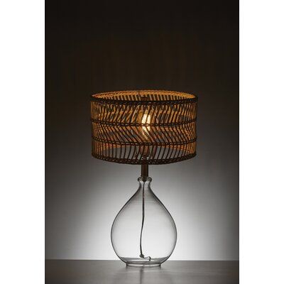 a table lamp with a glass base and wicker lampshade on the top