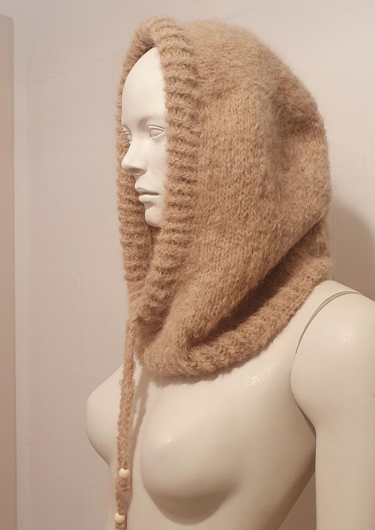 a mannequin wearing a knitted hat and scarf on it's head