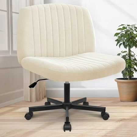 a white office chair sitting on top of a wooden floor next to a potted plant