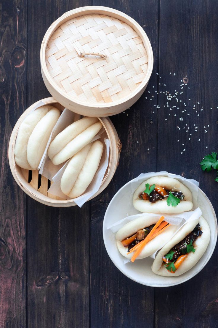 two bowls filled with food sitting on top of a wooden table