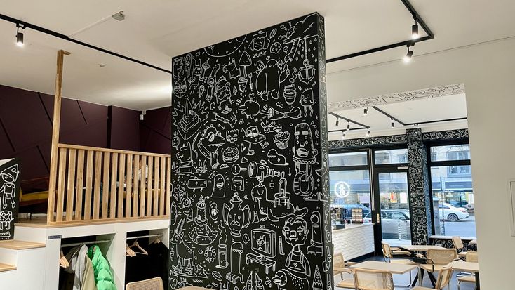 the interior of a restaurant with chalk drawings on the wall